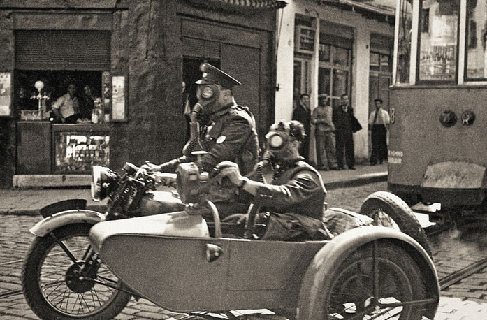 Namık Görgüç/Selahattin Giz: Gaz maskeli iki görevli Beyoğlu’nda sepetli motorsiklette, İstanbul, 1939. Yapı Kredi Tarih Arşivi